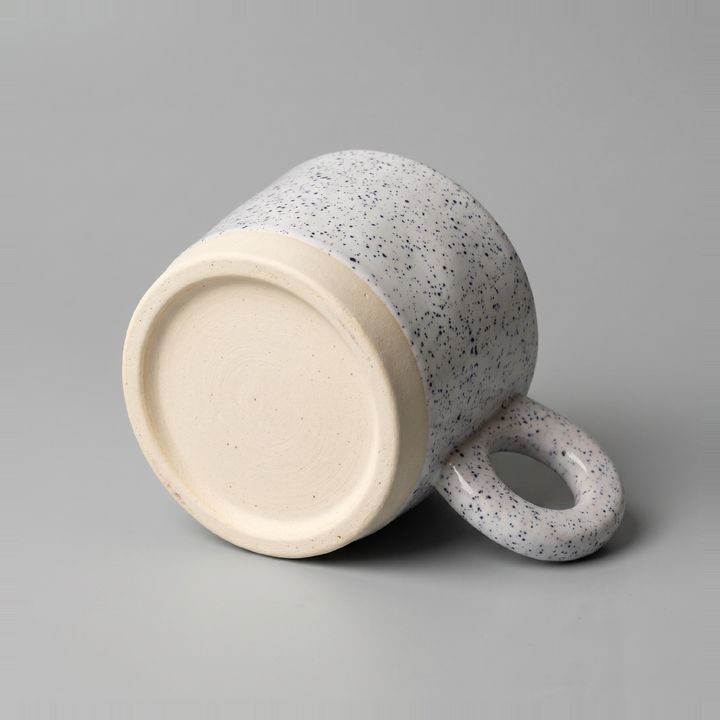 A second angled studio shot of the mug on a grey background